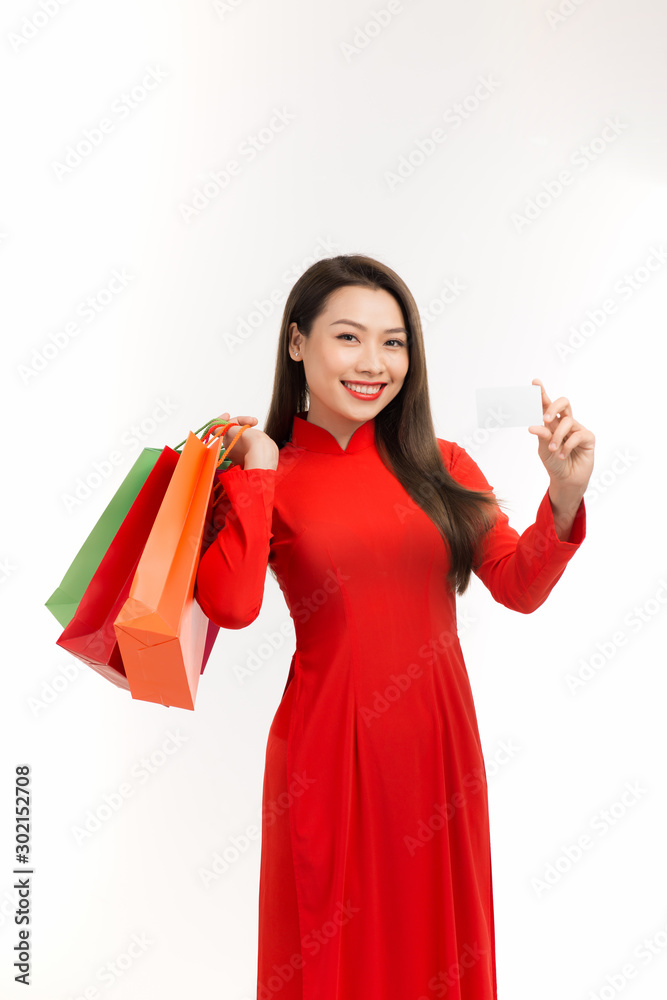 Beautiful Vietnamese young girl holding and posing with shopping bags on a white background