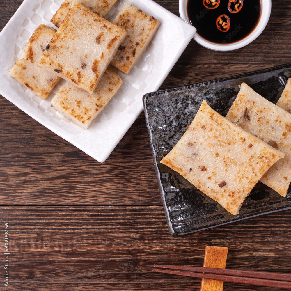 Delicious turnip cake, Chinese traditional radish cake in restaurant with soy sauce for new years d