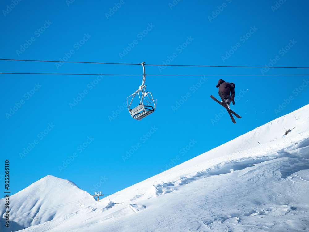 一名滑雪者在雪白的山脉中表演空中技巧