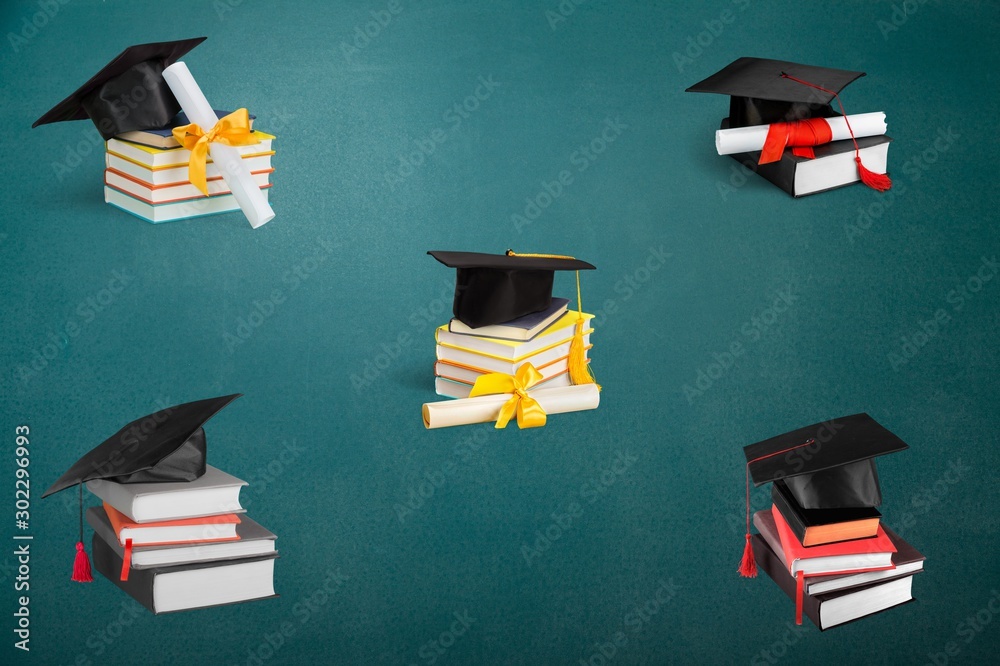 Graduation mortarboard on top of stack of books on  background