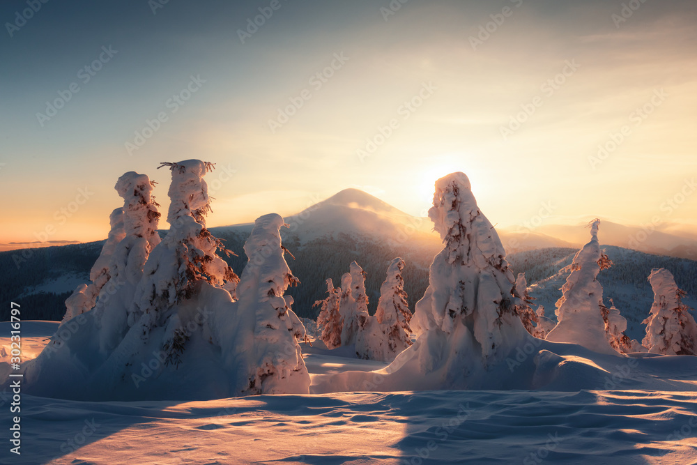 Fantastic winter landscape in snowy mountains glowing by morning sunlight. Dramatic wintry scene wit