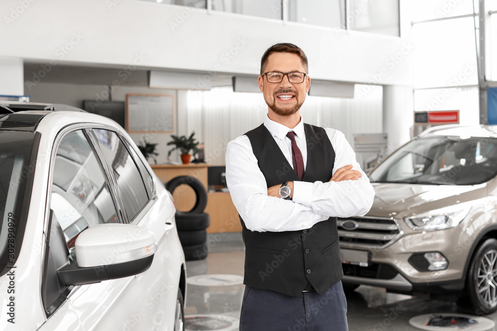 Salesman near car in modern salon