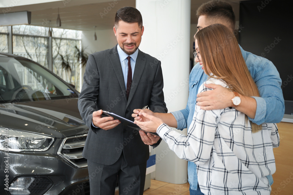 Couple buying new car in salon