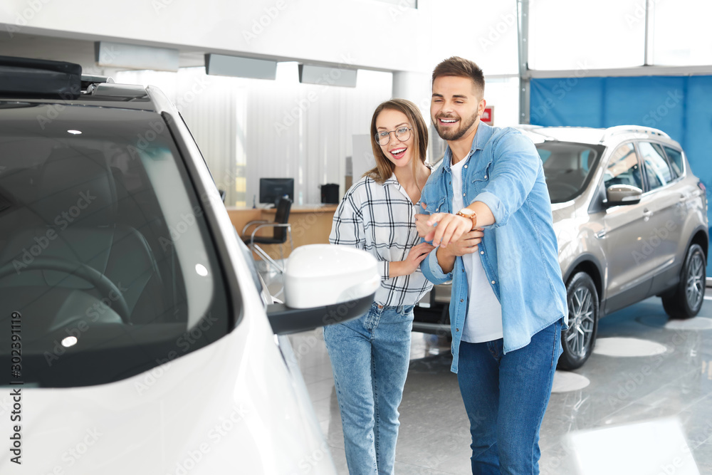 Couple buying new car in salon