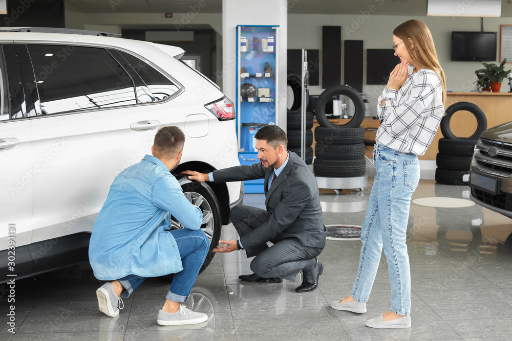 Couple buying new car in salon