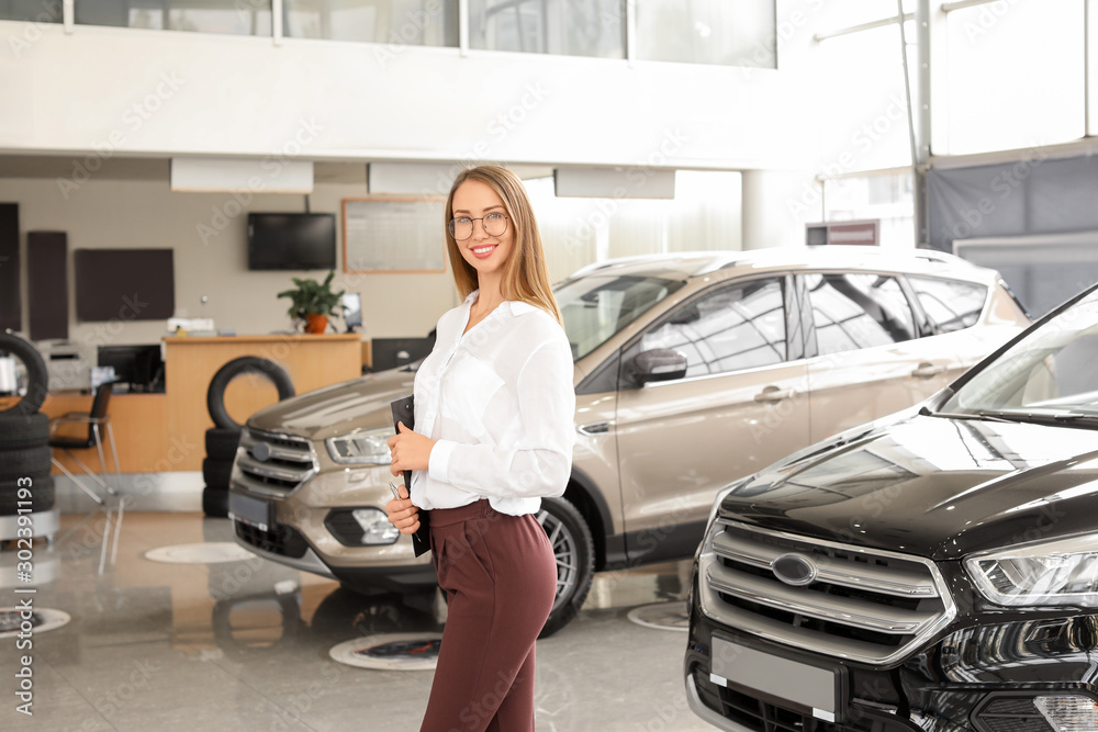 Saleswoman in modern car salon