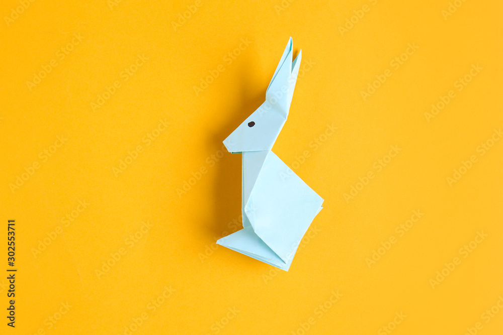 Origami rabbit on color background