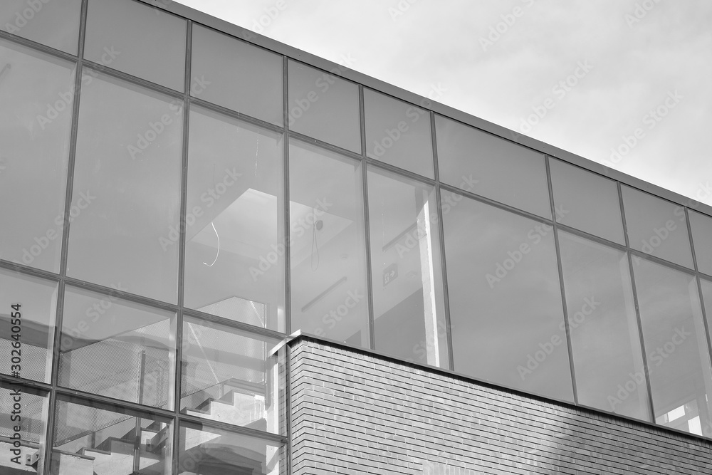 Curtain wall made of toned glass and steel constructions under sky. A fragment of a building. Black 