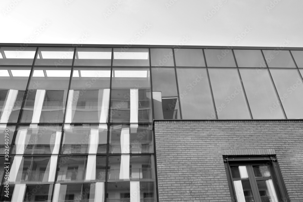 Curtain wall made of toned glass and steel constructions under sky. A fragment of a building. Black 