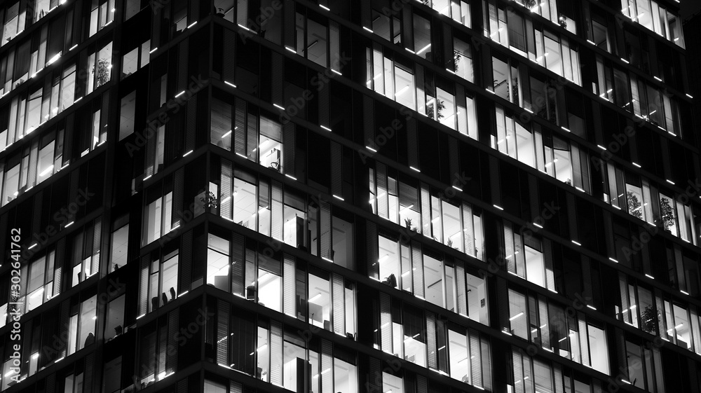 Pattern of office buildings windows illuminated at night. Lighting with Glass architecture facade de