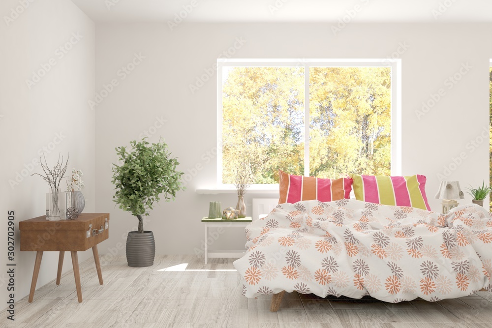 White stylish minimalist bedroom with armchair and autumn landscape in window. Scandinavian interior