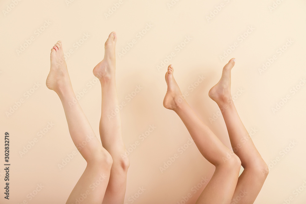 Women with beautiful legs after depilation on color background