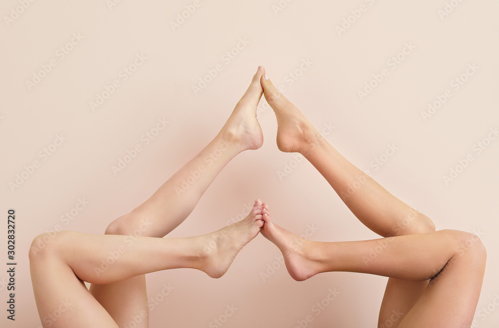 Women with beautiful legs after depilation on color background