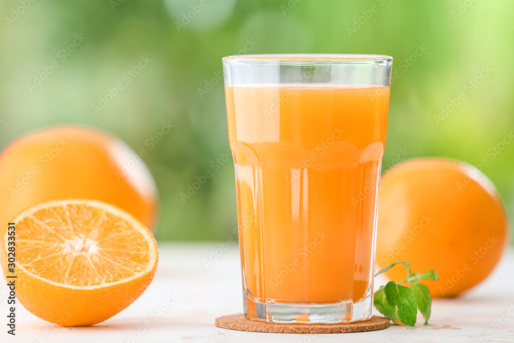 Glass of fresh orange juice on table outdoors