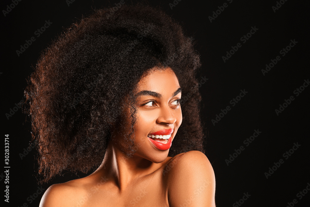 Portrait of beautiful African-American woman with bright lips on dark background