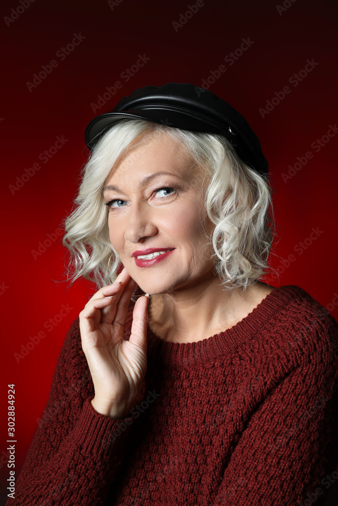 Portrait of stylish mature woman on dark color background