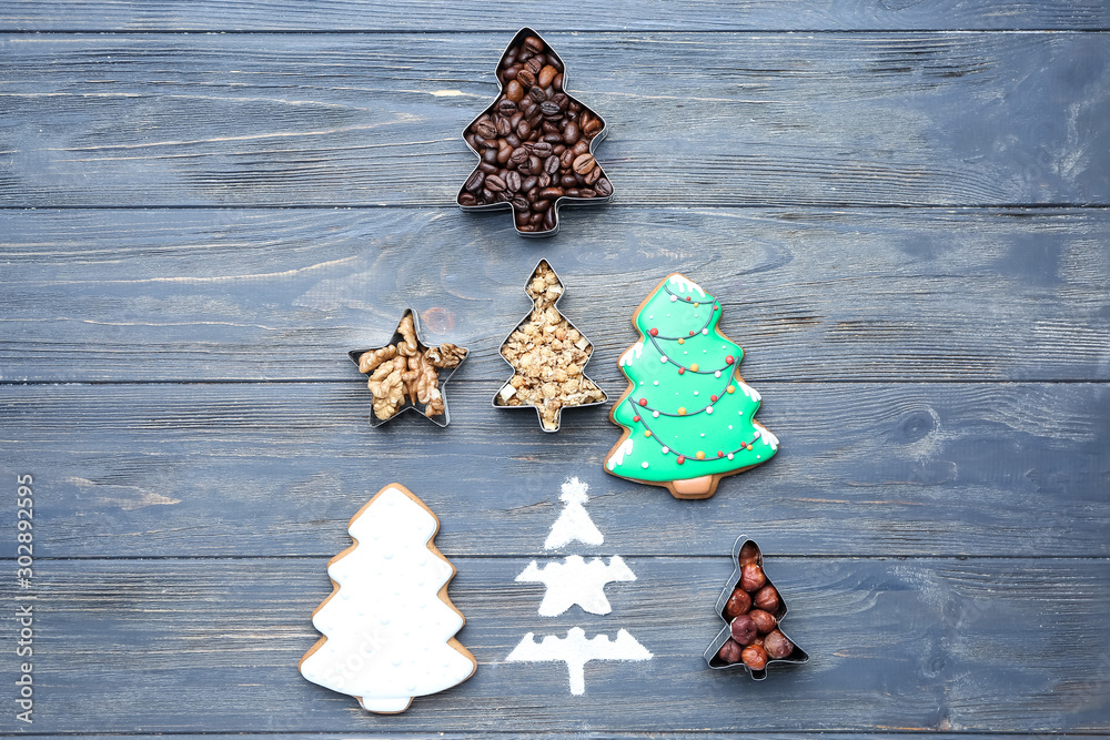 Christmas tree shape made of tasty cookies, nuts and coffee beans on color background