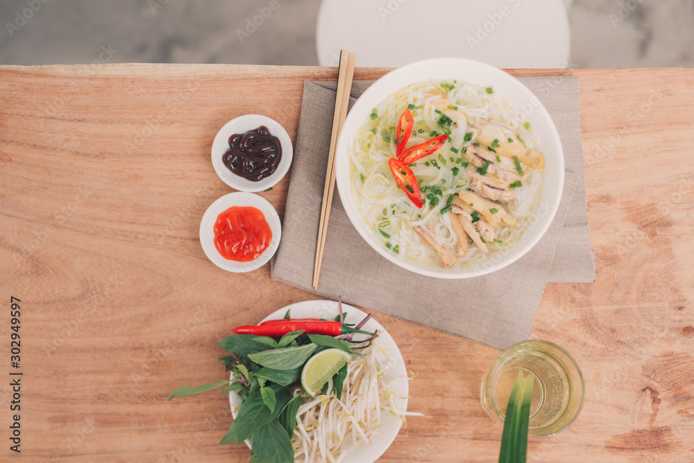 Pho Bo-越南新鲜米粉汤，配牛肉、香草和辣椒。正在倒高汤。越南