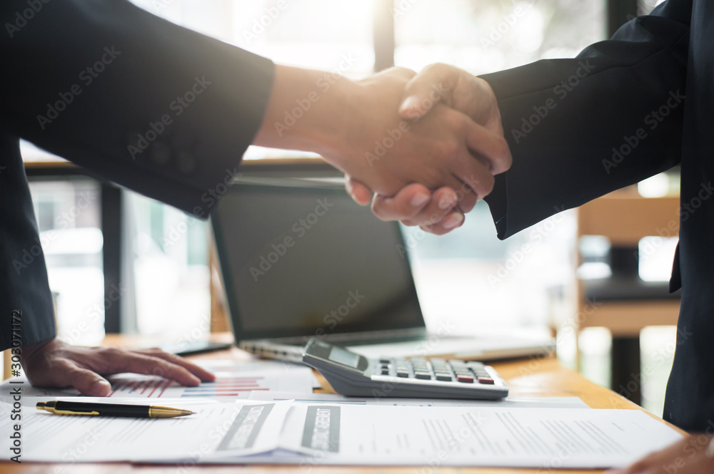 Business people shake hands after reaching a business agreement.