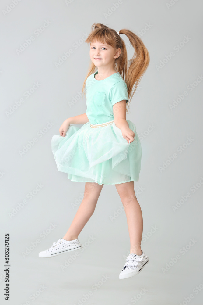 Cute carefree little girl on light background