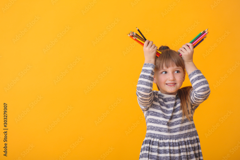 Cute little girl with pencils on color background