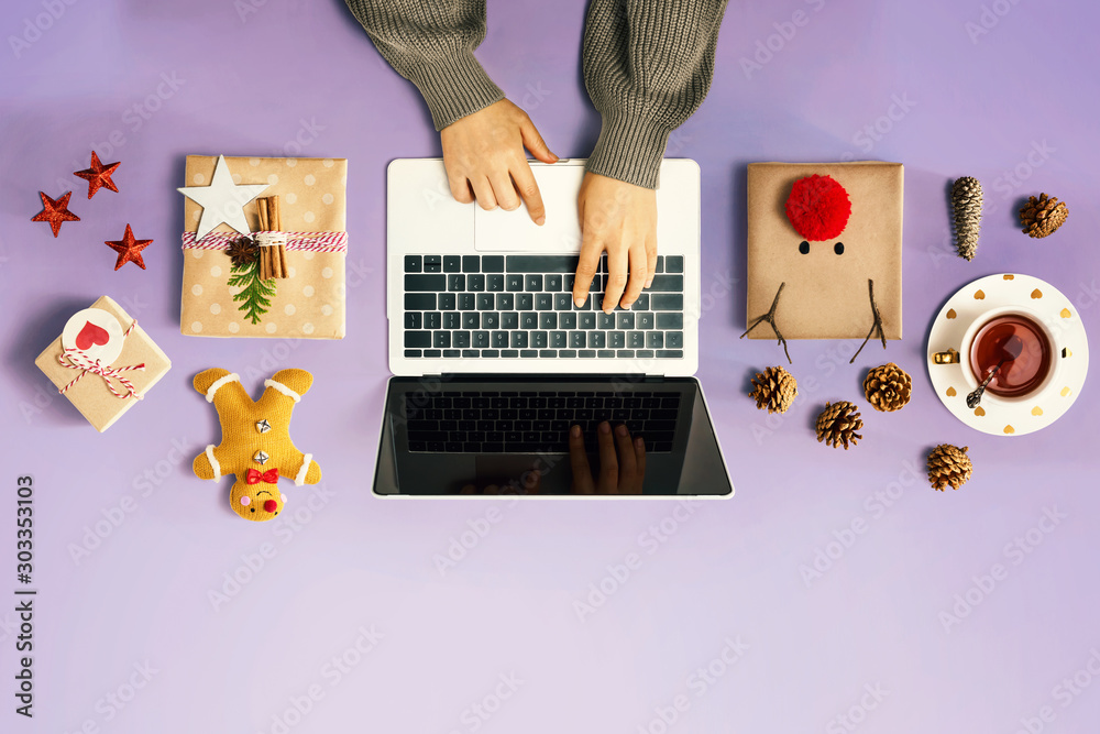 Christmas giftboxes with person using a laptop computer - overhead view