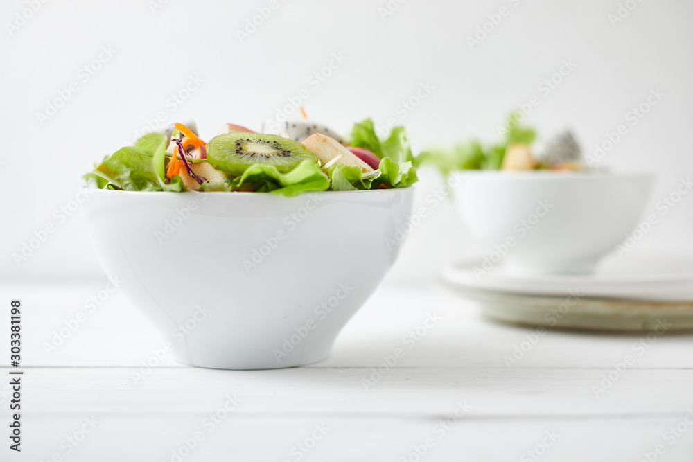 Delicious fruit salad and different fruits on the white table, healthy food concept.