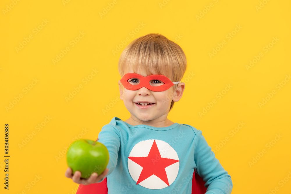 Superhero child holding apple