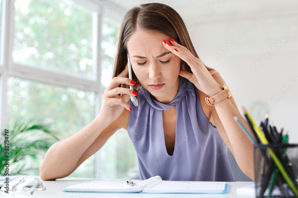 Tired young woman trying to meet deadline in office