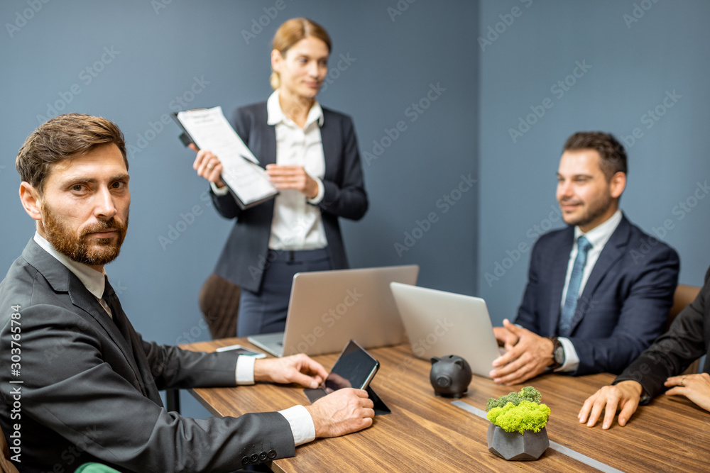 Portrait of a handsome business man sitting during a conference with business partners in the meetin