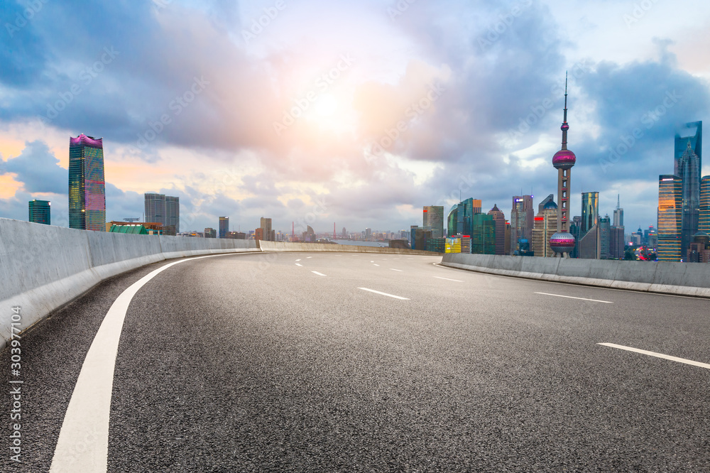 Empty asphalt highway and modern cityscape in Shanghai at sunset.