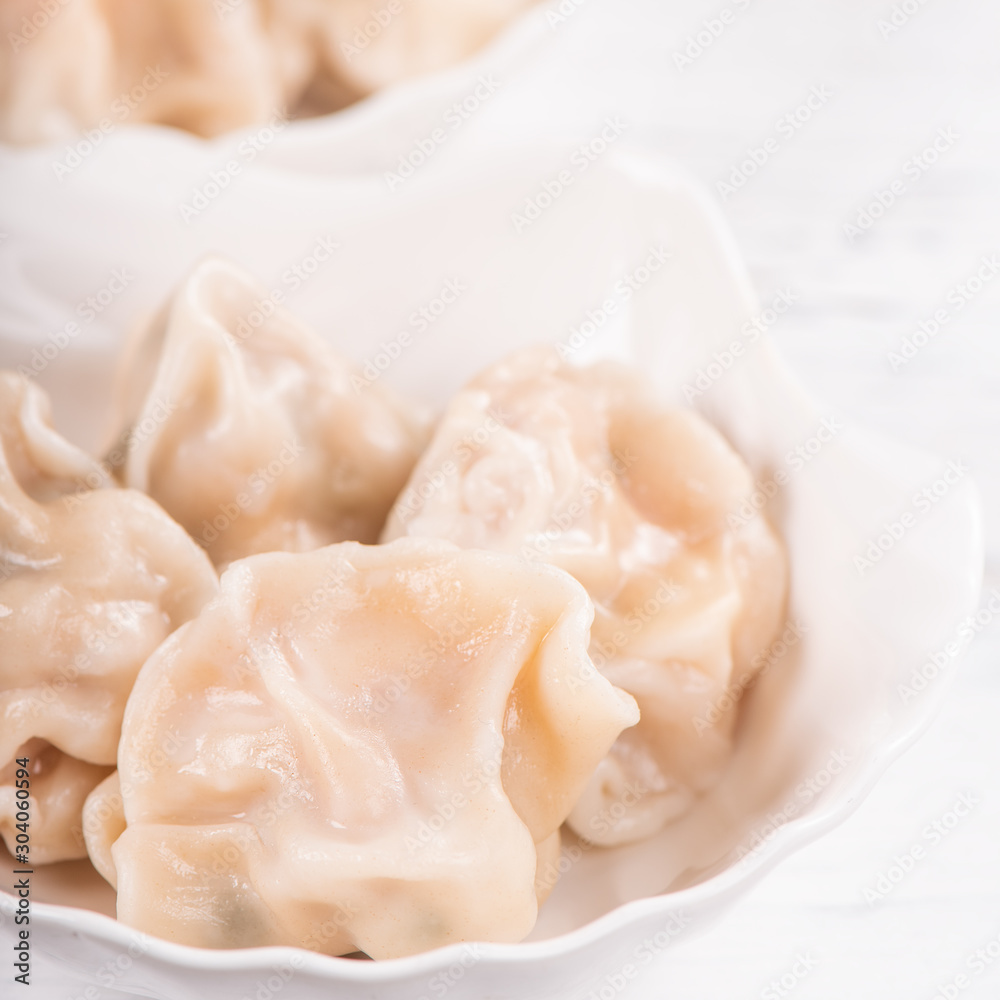 Fresh, delicious boiled pork, shrimp gyoza dumplings on white background with soy sauce and chopstic