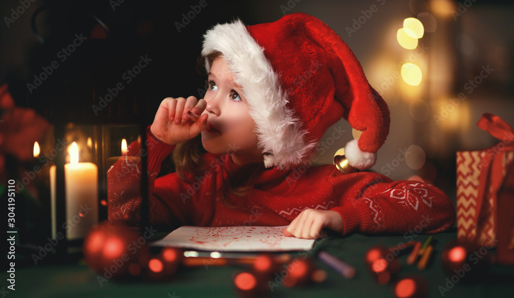 happy child girl writing letter santa home near Christmas tree.