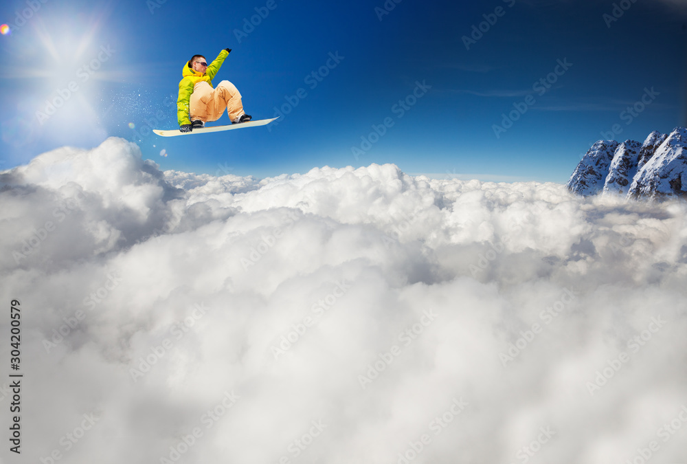 Snowboarder man jump over the snow white clouds