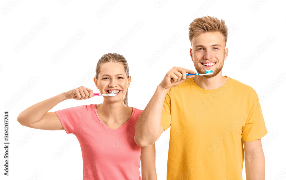 Young couple brushing teeth on white background