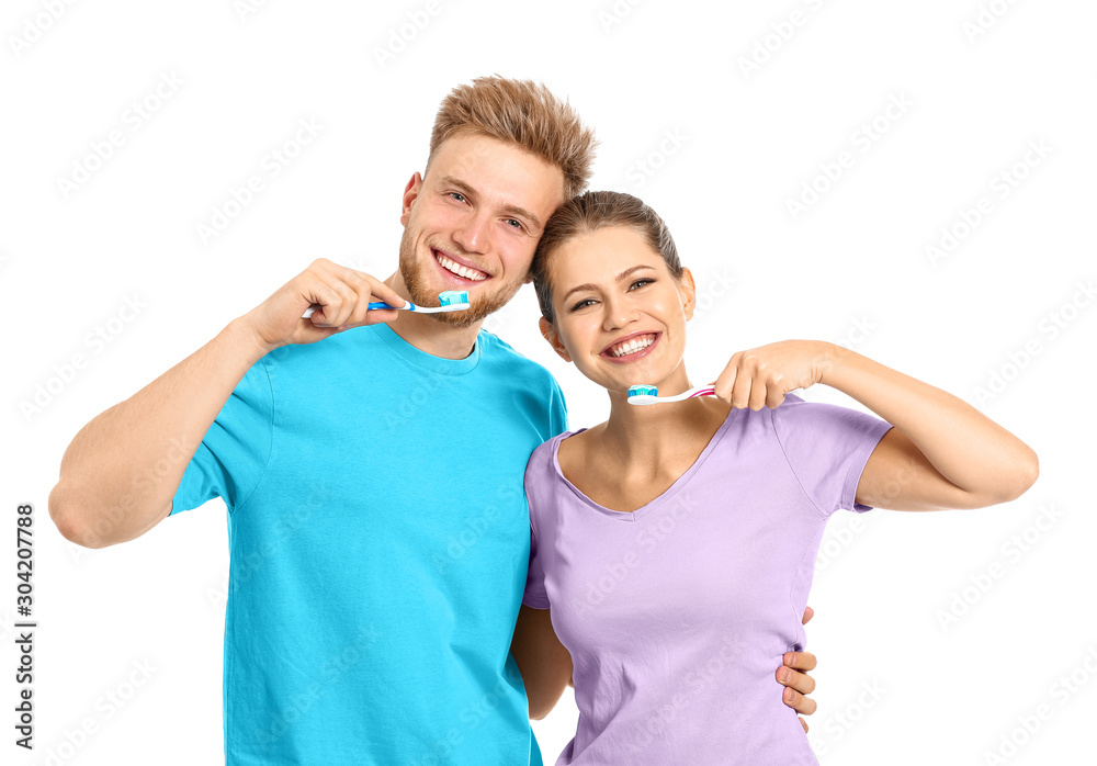 Young couple brushing teeth on white background