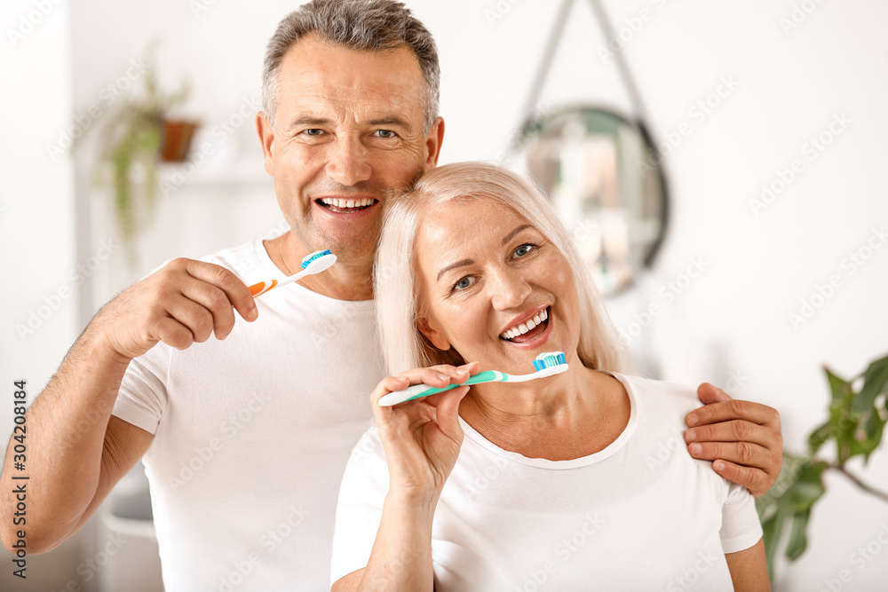 Mature couple brushing teeth at home