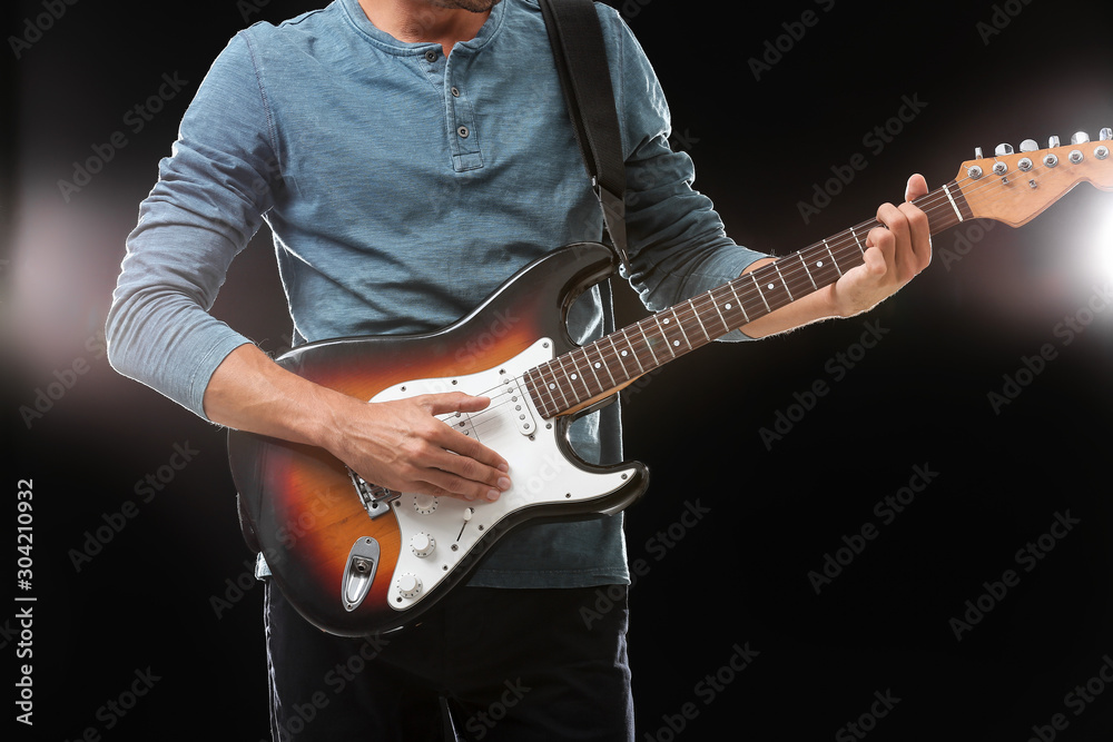 Handsome man playing guitar on stage