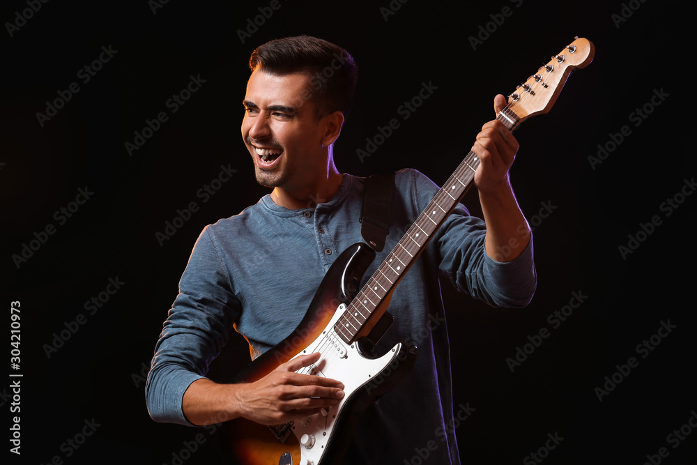 Handsome man playing guitar on stage