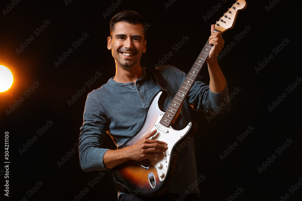 Handsome man playing guitar on stage