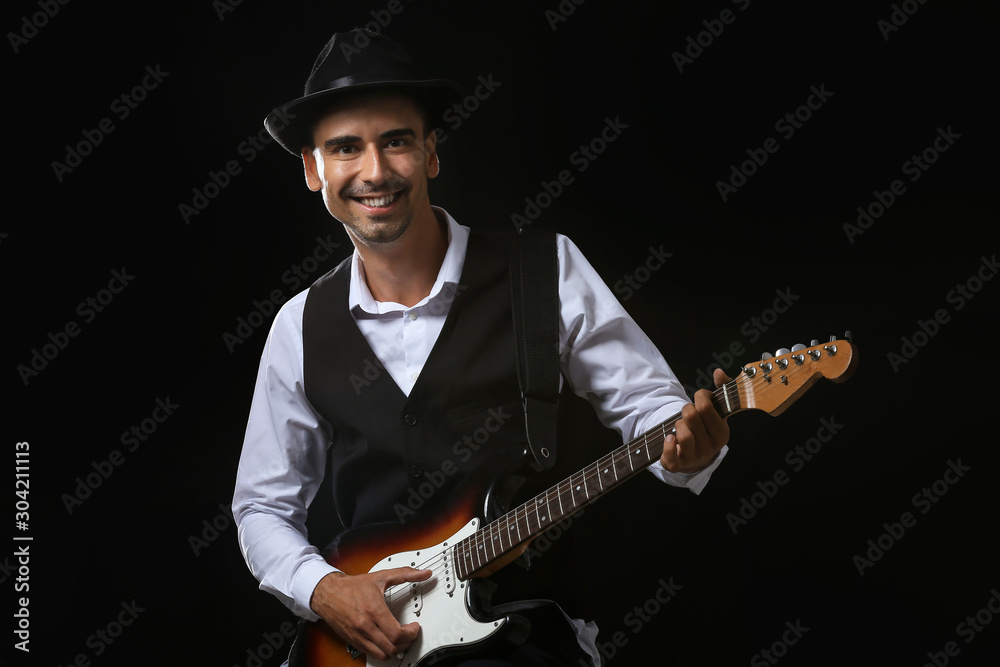 Handsome man playing guitar on stage