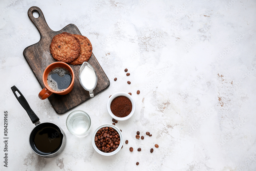 Cup of hot coffee with milk and cookies on light background