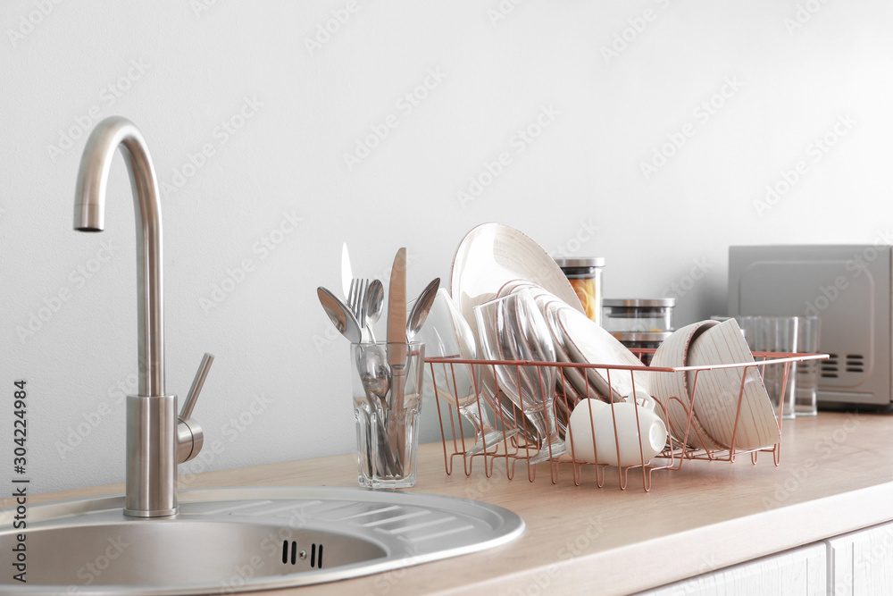 Set of clean dishware near kitchen sink