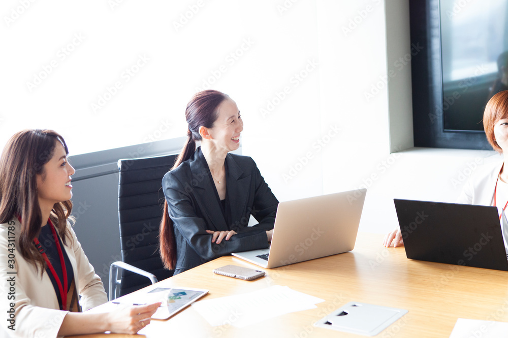 笑顔で会議をする女性社員