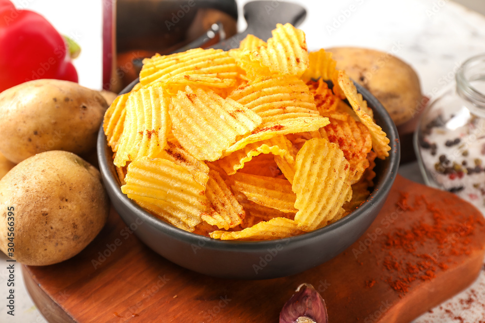 Tasty potato chips and bell pepper on table