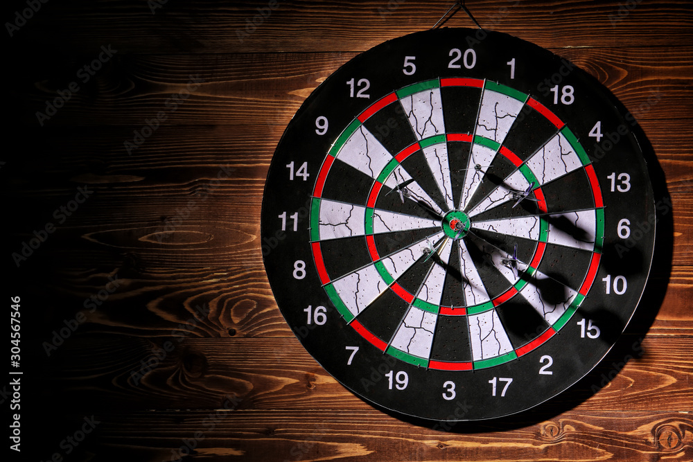 Dartboard hanging on wooden wall