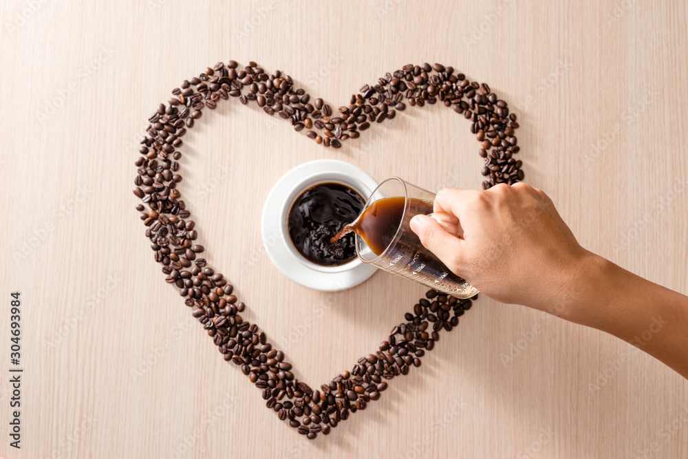   White cup of coffee beans on wooden background