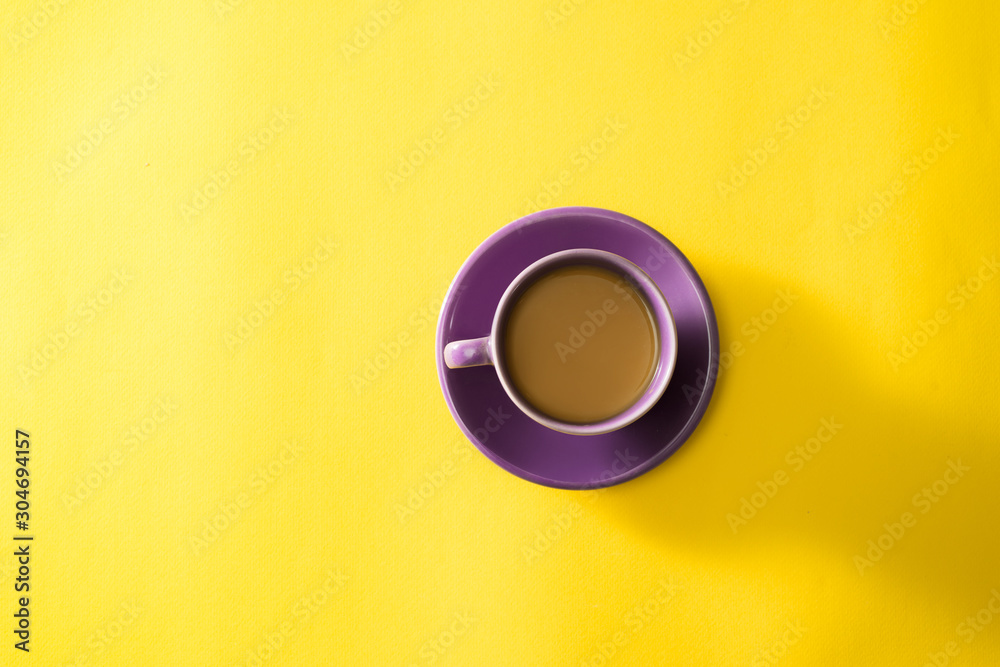 Purple cup of coffee on the yellow background