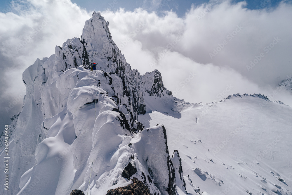 一名登山运动员在冬季极端条件下攀登高山山脊。冒险攀登高山i峰