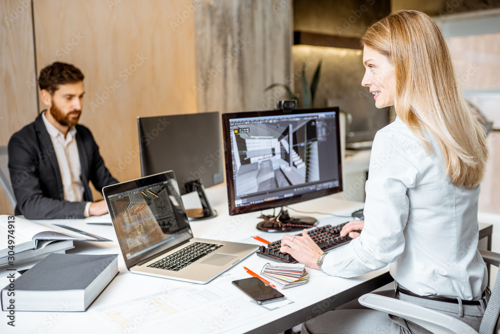 Creative office employees making interior design on the computers, sitting at the modern office of a